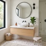 “A modern, stylish bathroom interior featuring terrazzo design elements, including terrazzo flooring and a matching vanity countertop. The space has a trendy, airy aesthetic with soft natural lighting coming through a large window. Minimalist decor with sleek black or brass fixtures, a round mirror with a thin frame, indoor plants for freshness, and neutral tones like white, beige, and soft gray. The terrazzo pattern is colorful yet balanced with subtle specks of pastel pink, grey, and beige. Ultra-realistic, high-end interior design photography, 4K resolution, Pinterest aesthetic, clean composition, soft shadows, luxurious yet cozy vibe.”